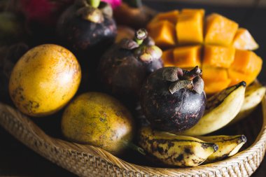 Mango, tutku meyve, mangosten, ahşap masa üzerinde dragonfruit ile meyve tabağı