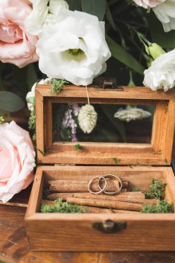 Tarçın üzerinde iki yüzük ile ahşap vintage kutu çiçek buketi ile dekore edilmiştir.