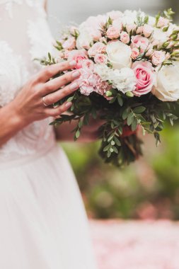 Nazik düğün buket pembe ve beyaz gül elinde tutan gelin