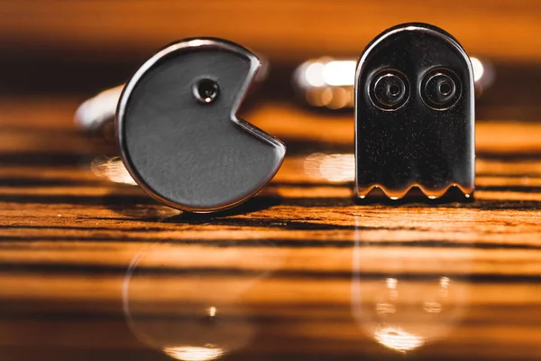 ahşap arka plan üzerinde Pacman şeklinde kol düğmeleri, yakın çekim