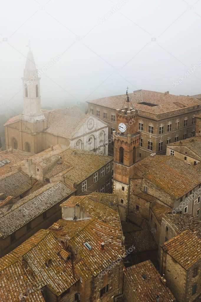 Aerial view of ancient italian town Pienza in Tuscany. Tile brown roofs, old town hall, narrow streets and church.