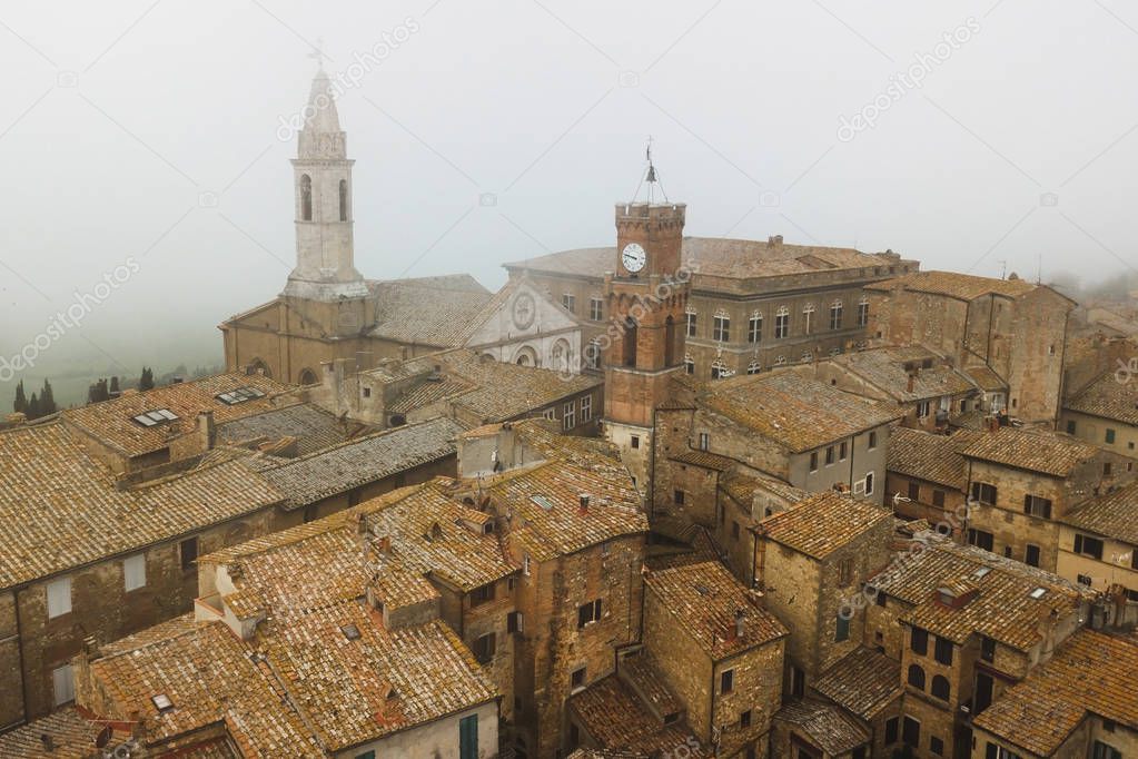 Aerial view of ancient italian town Pienza in Tuscany. Tile brown roofs, old town hall, narrow streets and church.