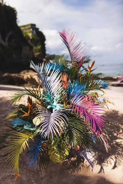 Tropical beach ceremony with painted colorful palm leaves