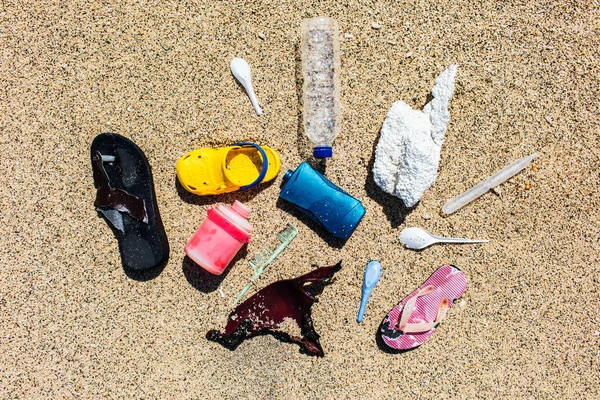 Různé typy plastových odpadů shromážděných na pláži na písku ba — Stock fotografie