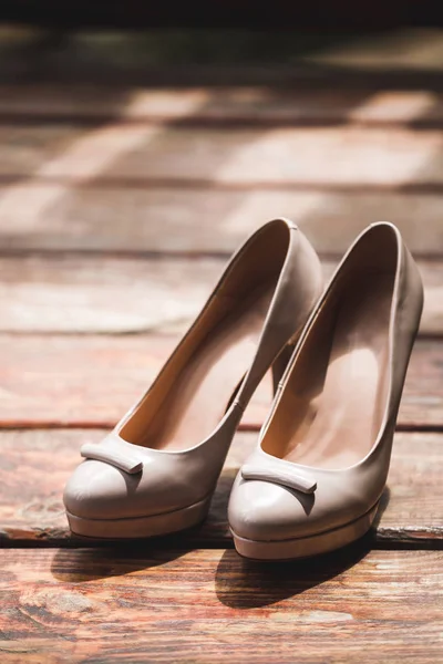 Classiche scarpe da donna beige moda sui tacchi alti primo piano su legno — Foto Stock