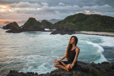 Lotus 'da yoga yapan genç kadın Bev bugün ile günbatımı poz
