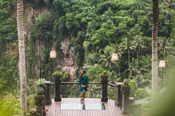 Азіатський брюнетка жінка в зеленій сукні на балконі з дивовижною Юнга — стокове фото