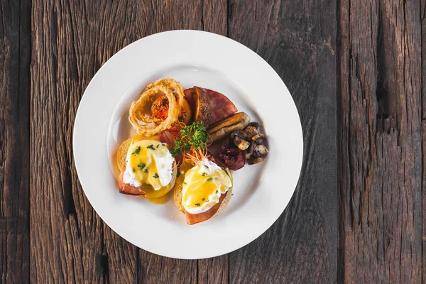 Ägg Benedict på trä bakgrund uppifrån — Stockfoto