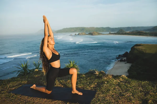 Femeia care practică yoga în aer liber cu ocean uimitor și munte v — Fotografie, imagine de stoc