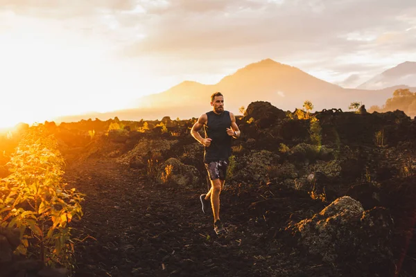 Young male athlete trail running in mountains at sunrise. Amazin — Stock Photo, Image