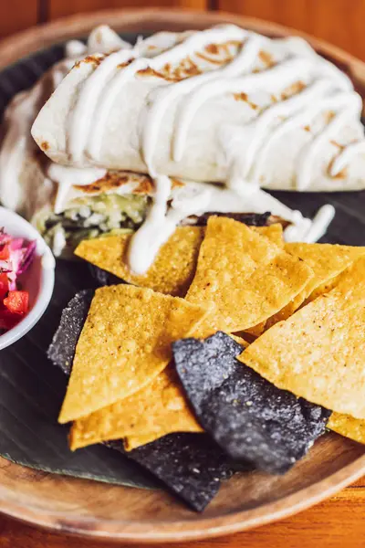 Patatine nacho di mais guarnite con guacamole, formaggio fuso su legno — Foto Stock