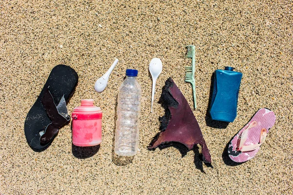 Különböző típusú műanyag hulladékot gyűjtött a strandon a homok-ba — Stock Fotó