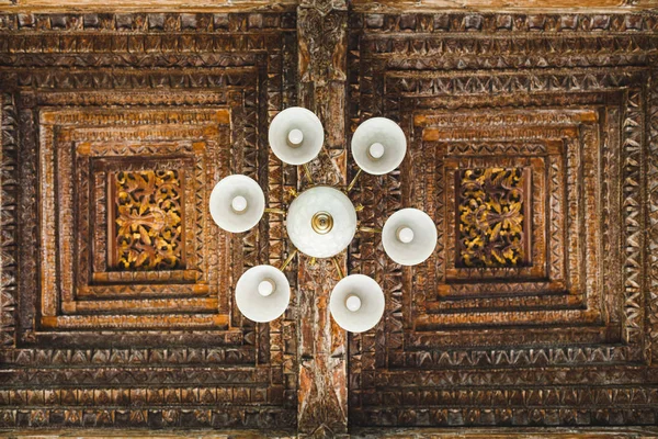 Weißer Kronleuchter auf dem Hintergrund der handgefertigten hölzernen Decke Dach i — Stockfoto