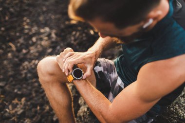 Genç atletik adam r önce fitness izci veya akıllı saat kullanarak