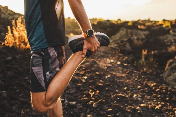 Männlicher Läufer streckt Bein und Füße und bereitet sich auf das Laufen vor — Stockfoto