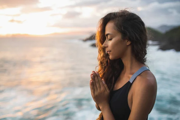 Young woman praying and meditating alone at sunset with beautifu — Stock Photo, Image