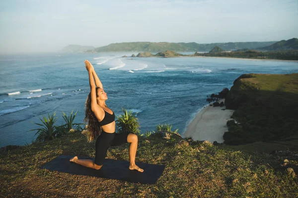 Woman practicing yoga outdoors with amazing ocean and mountain v — Stock Photo, Image