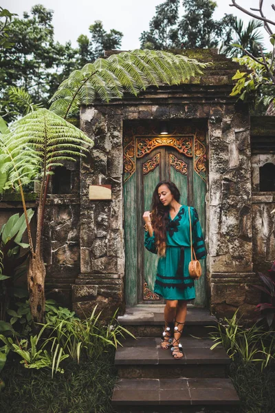 Азиатская брюнетка в зеленом платье с ручной работы сцепления мешок pos — стоковое фото