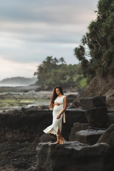 Giovane donna incinta in abito bianco godendo sera a Bali bea — Foto Stock