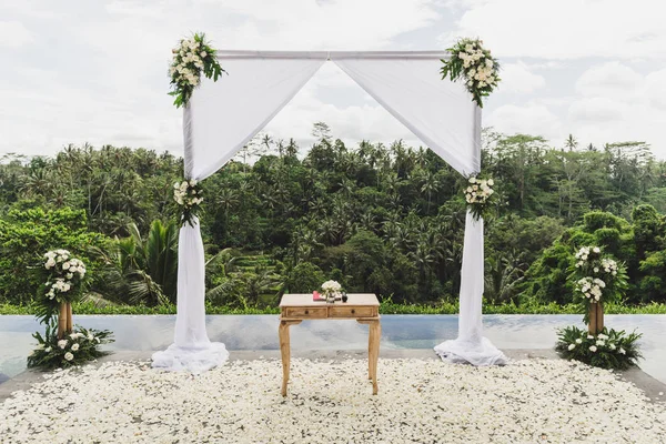 Bianco matrimonio cerimonia arco nella giungla tropicale sul bordo del blu i — Foto Stock