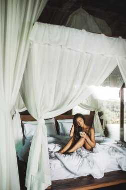 İnce tan kadın uyanma ve kasadan sabah kahve enjoyning