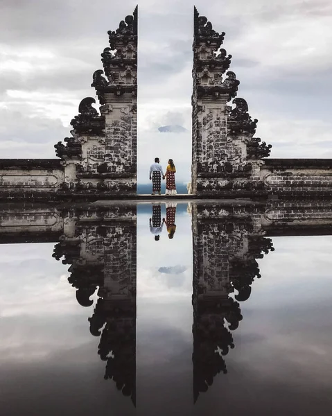 Couple in Pura Lempuyang temple Gate with mirror reflection. Tou — Stock Photo, Image