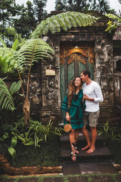 Pareja feliz en el amor sonriendo y besándose en el fondo de tradit —  Fotos de Stock