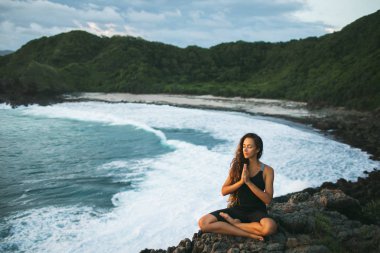 Genç kadın dua ve beautifu ile gün batımında yalnız meditasyon