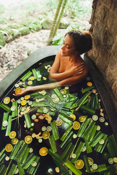 Hermosa joven disfrutando en el spa al aire libre. Baño de piedra de lujo —  Fotos de Stock