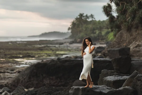 Giovane donna incinta in abito bianco godendo sera a Bali bea — Foto Stock