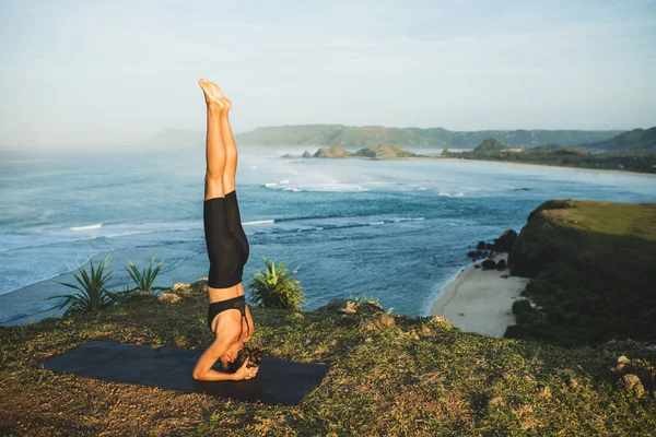 Mujer practicando yoga y haciendo pose de mano al aire libre con ama —  Fotos de Stock