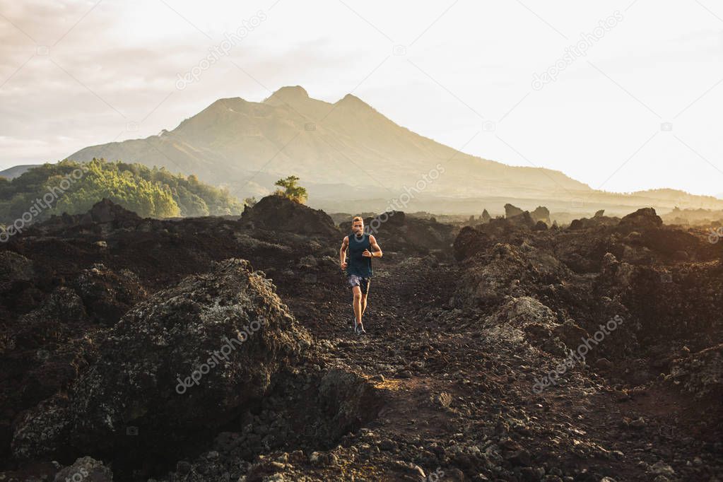 Young athlete man trail running in mountains in the morning. Ama