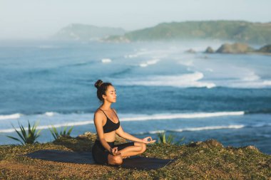 Kadın yoga ve lotus oturan ama ile açık poz
