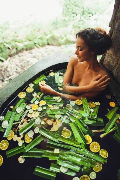 Bella giovane donna godendo in spa all'aperto. Bagno di pietra di lusso — Foto Stock