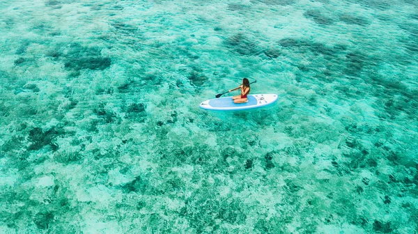 Frau sitzt auf Sup Board und genießt türkisfarbenes transparentes Wasser — Stockfoto