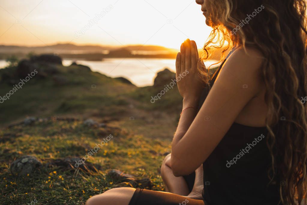 Woman praying alone at sunrise. Nature background. Spiritual and