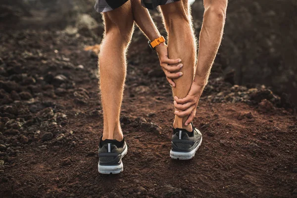 Male runner holding injured calf muscle and suffering with pain. — Stock Photo, Image