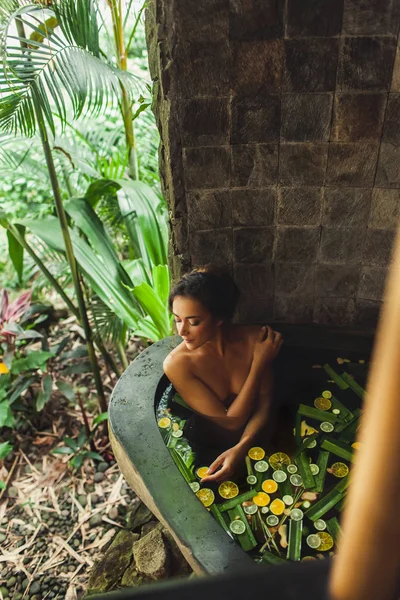 Mulher bonita desfrutando no spa ao ar livre. banho de pedra de luxo — Fotografia de Stock