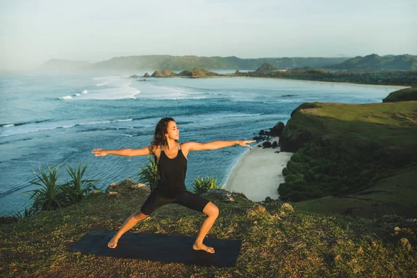 Γυναίκα εξάσκηση γιόγκα σε εξωτερικούς χώρους με εκπληκτικό ωκεανό και βουνό v — Φωτογραφία Αρχείου