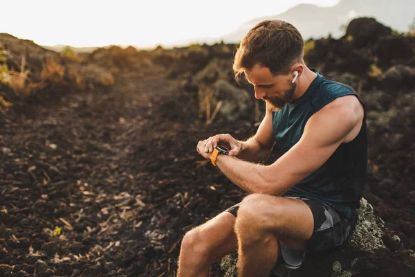 Corredor verificando los resultados del entrenamiento en smart watch. Hombre atleta nosotros — Foto de Stock