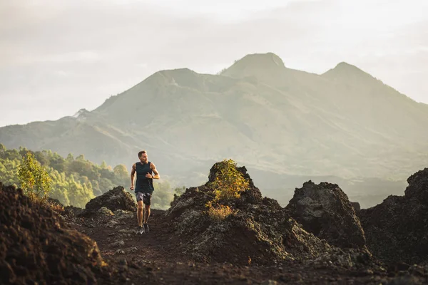Young athlete man trail running in mountains in the morning. Ama — Stock Photo, Image