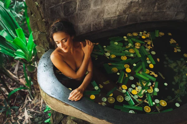 Schöne junge Frau genießt im Outdoor-Spa. Luxus-Steinbad — Stockfoto