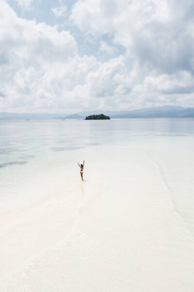 Woman walking alone on amazing tropical white sand beach. Aerial