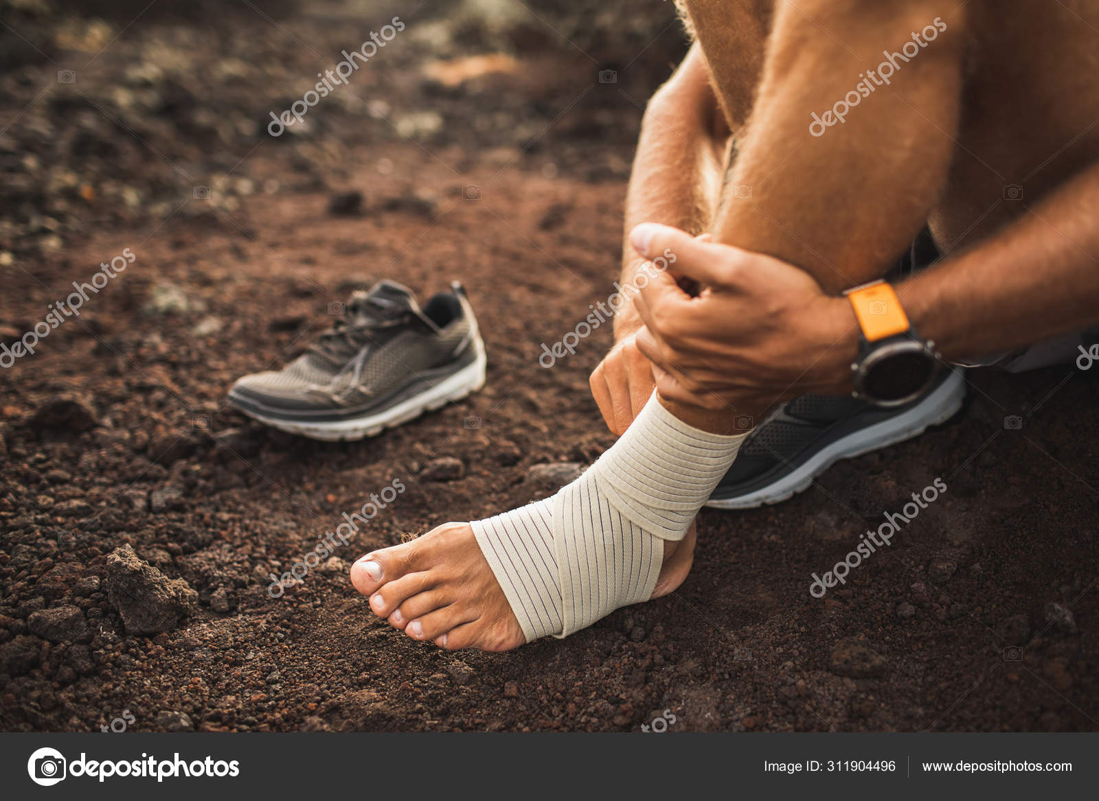 Man bandaging injured Injury leg while running outdoors