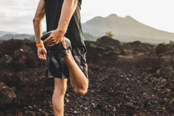 Corredor estirando pierna y pies y preparándose para el trail running o — Foto de Stock