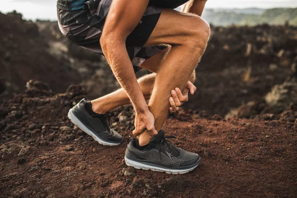 Achilles injury on running outdoors. Man holding Achilles tendon — Stock Photo, Image
