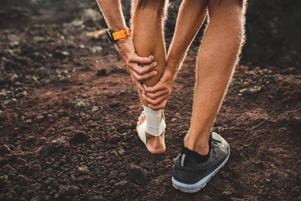 Male runner holding injured calf muscle close-up and suffering w — 图库照片