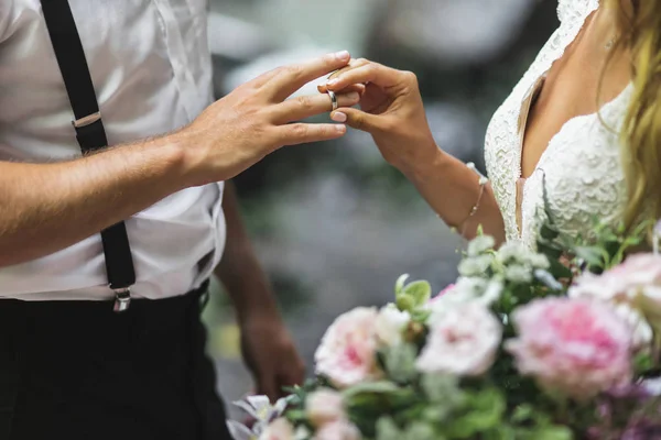 Bride putting wedding ring on groom's hand close up. Symbol of l — Stock Photo, Image