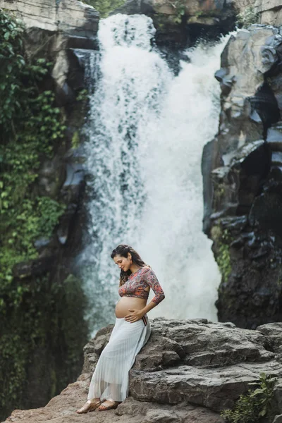 Jovem mulher grávida autêntica perto de cachoeira cascata incrível. N — Fotografia de Stock