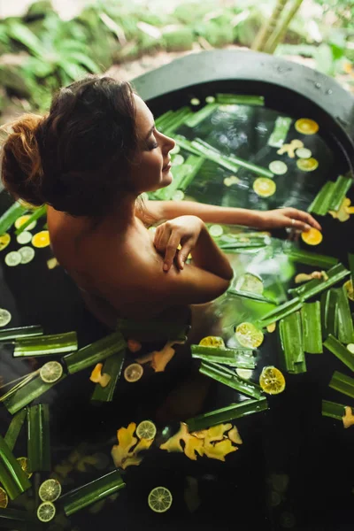 Wanita muda yang cantik menikmati spa di luar ruangan. Mandi batu mewah — Stok Foto